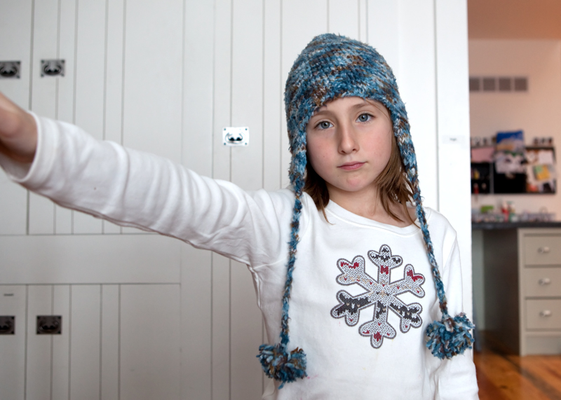 Child reluctantly poses in new hat